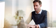 Jonge ondernemer is vanuit huis aan het werk op zijn laptop