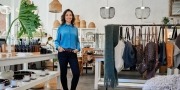 Vrolijke jonge ondernemer in haar eigen trendy winkel