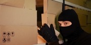 Inbreker pakt een doos uit lading goederen